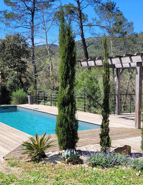 Piscine et jardin méditerranéen: Cyprès, agave et terrasse bois. Piscine contemporaine à terrasse bois, bordée de cyprès et d'agaves. Vue panoramique sur la forêt méditerranéenne et pergola.